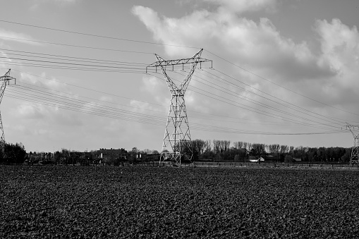 Black and white photo of an electricity pylon in the agricultural landscape