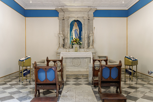 A small room with a statue of a woman and two chairs