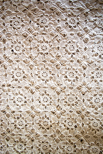 Background of a white rectangular crochet napkin. Needlework crocheted canvas. White crochet fabric with repeating pattern