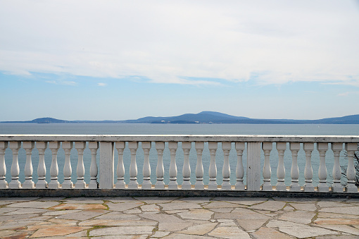 stone railings of the open terrace overlooking the seascape.