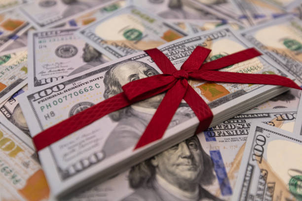 istock pile of US 100 dollar banknotes with bow on dollar background 2148747475