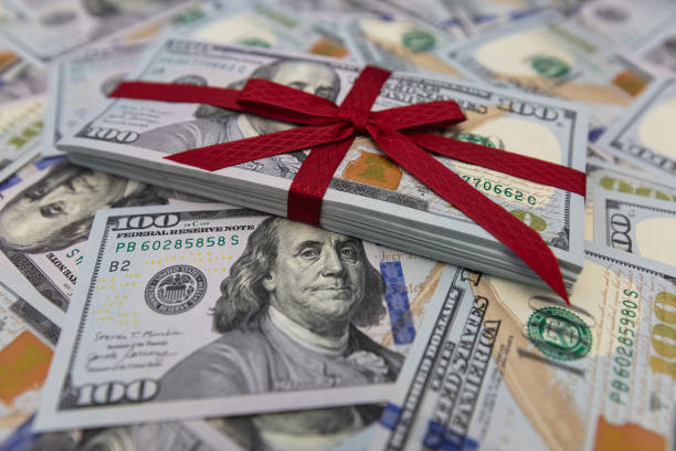 istock pile of US 100 dollar banknotes with bow on dollar background 2148747476