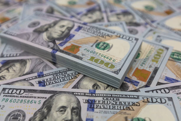 istock Pile of US 100 dollar banknotes on dollars background 2148747579