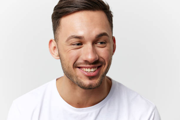 istock Joyful cute happy young tanned handsome man in basic t-shirt laugh at camera posing isolated on over white studio background. Copy space Banner Mockup. People emotions Lifestyle concept. Portrait 2148747857