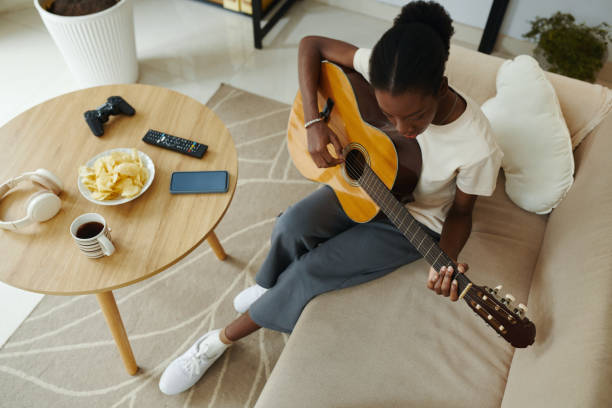 istock Young Woman Learning Playing Guitar 2148749316