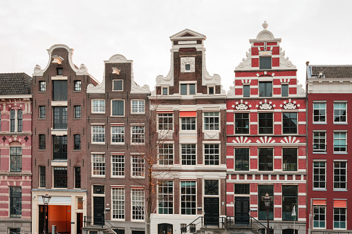 Amsterdam, Netherlands - March 28, 2023: Iconic houses along the canal across from the train station in Amsterdam