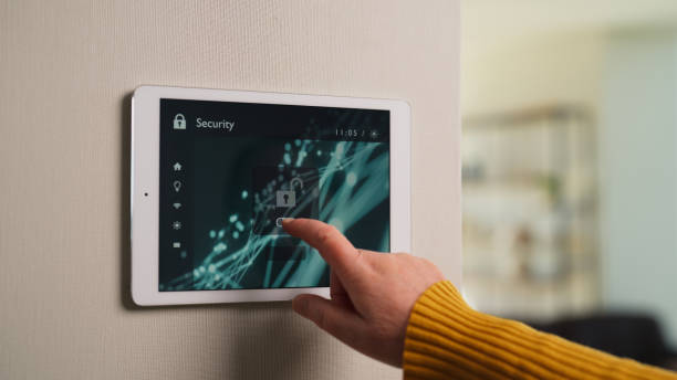 Close-up video of senior woman activating artificial intelligence smart home security system in smart house before leaving house