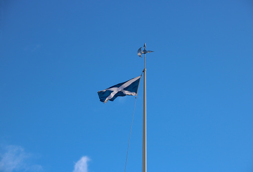Scottish national saltire flag flying on a battleaxe flagpole at Bannockburn battlefield site in Stirling Scotland