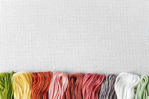 istock flat lay for needlework and cross-stitch: multi-colored mouline thread on a white canvas aida 16 counts, place for text 1 2148751194