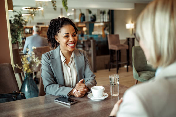istock Two female colleagues talking during coffee break at the restaurant 2148751523