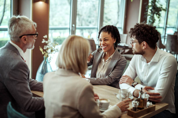istock Group of well dressed business people talking during coffee break at the restaurant 2148751564
