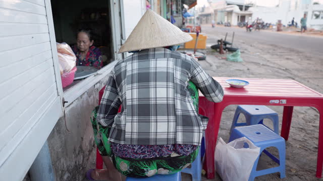 Vietnamese woman eating a pho bo, South Vietnam