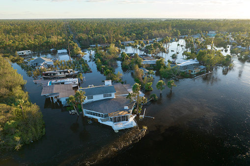 Consequences of natural disaster. Heavy flood with high water surrounding residential houses after hurricane rainfall in Florida residential area.