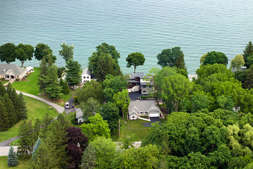Aerial view of spacious family houses on lake Ontario shore in upstate New York suburban area. Real estate development in American suburbs.