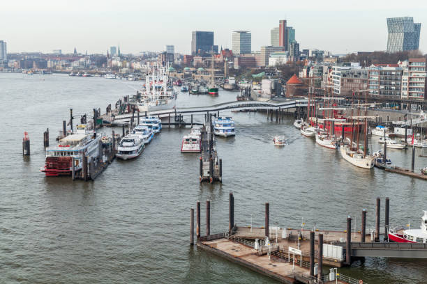 Hamburg, Germany - November 30, 2018: Elbe river coastal photo taken on a cloudy day. Boats are moored at floating piers