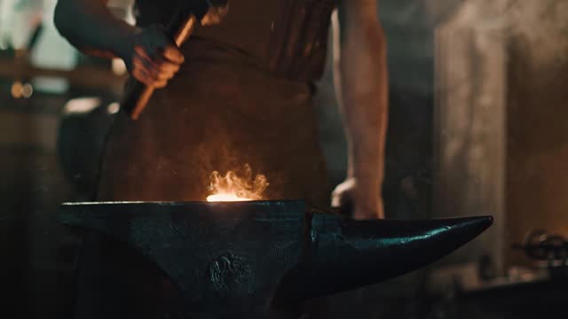 Close-up of an incandescent piece of metal, hammered on the anvil. stock video