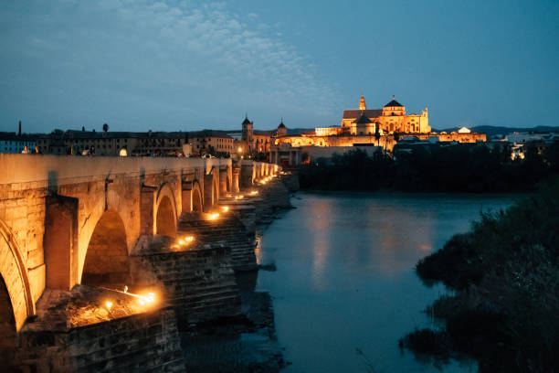 Cordoba skyline at sunset. Illuminated bridge with the Cathedral-Mosque in the background.