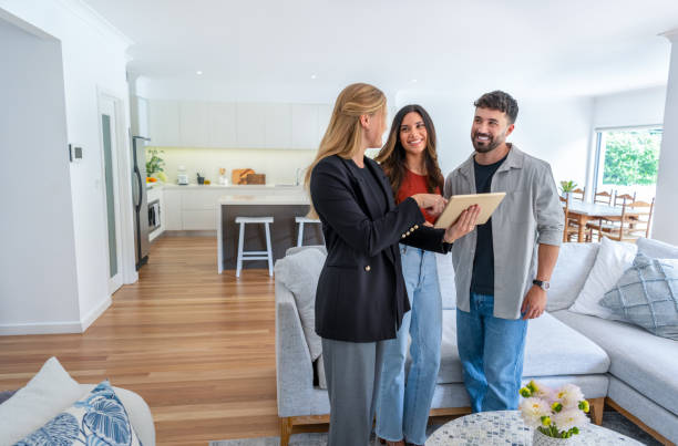 real estate agent or architect showing a couple a new home. - inmobiliaria fotografías e imágenes de stock