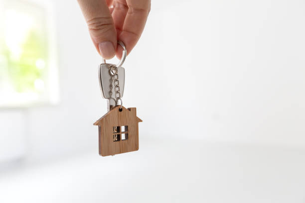 istock Home key in hand at empty room with new flat background 2148757565