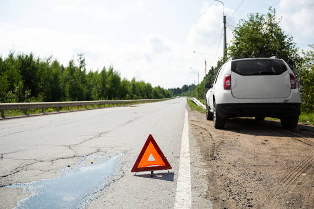 istock Car and red triangle emergency stop sign on asphalt road 2148757899
