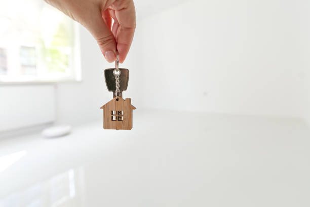 istock Home key in hand at empty room with new flat background 2148757906