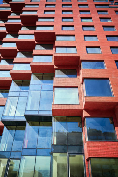 istock Part of a new multi-story abstract red office building under construction from below 2148758310