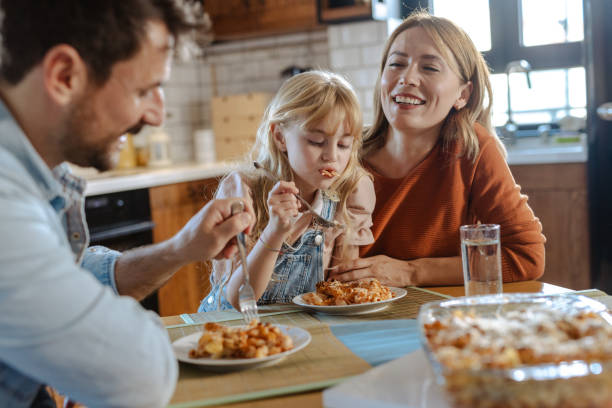 istock Happy family eating and talking at the table 2148758714