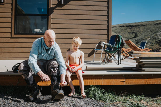 Young boy sits with Grandfather while he gets ready for a fishing trip