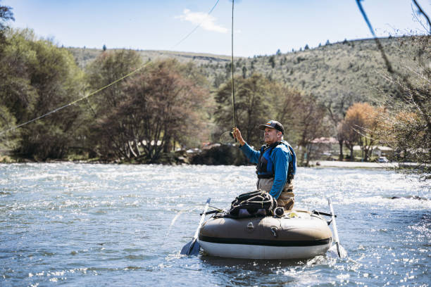 istock Middle aged man fly fishes from an inflatable boat 2148761492