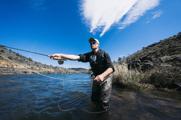istock Active man catches fishes while standing in the river 2148761494
