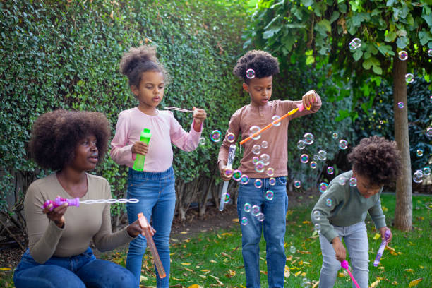 istock Happy family playing soap bubbles on a picnic for bonding time together on grass in summer 2148763577