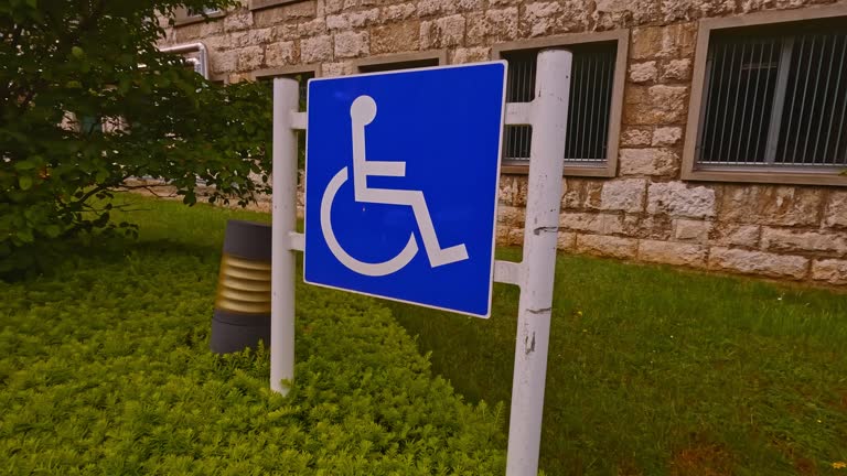 Wheelchair accessible parking sign in front of a stone building in Luxembourg