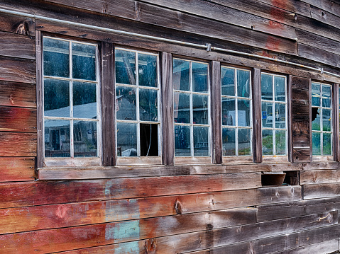 Old dusty windows at the Jensen boat house on San Juan Island let in some light and show reflections of the rest of the shipyard.