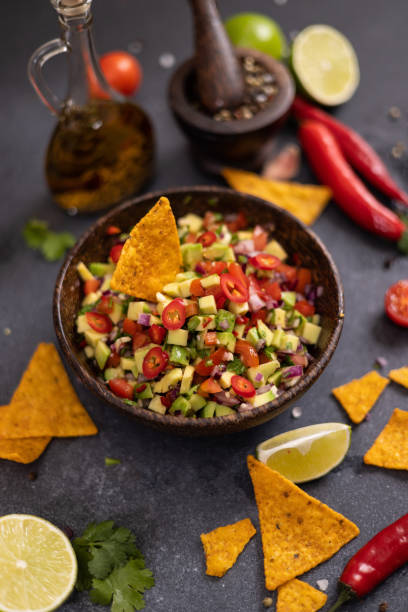 istock traditional salsa dip snack in wooden bowl and corn nacho chips on a table with ingredients 2148765524