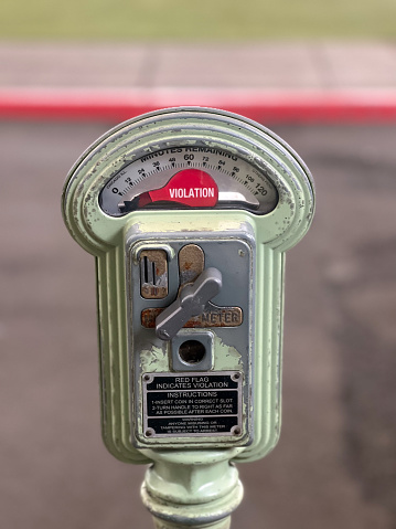 Vintage authentic old American parking meter on city street parking space.