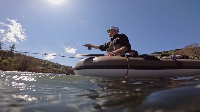 Man fly fishing from inflatable raft