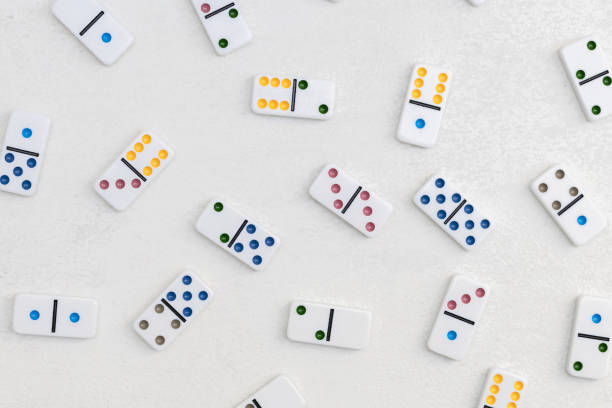 istock White dominoes with colorful dots on a white cement background, top view. Board game. 2148770523