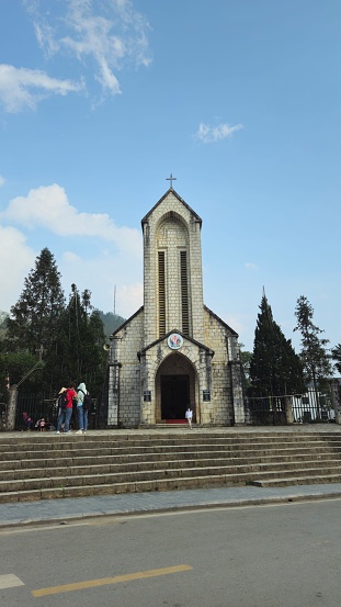 Sapa town, Vietnam - March 28, 2024: Tourists visit Sapa church, known as the Church of Our Lady of the Rosary, attractive place for sightseeing in Sapa.
