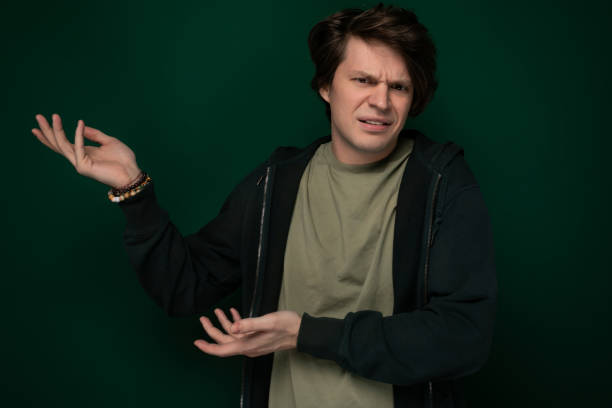 Man in Black Jacket Holding Out Hands A man wearing a black jacket is standing with his hands held out in front of him. His body language suggests he might be expecting to receive something or offering assistance. male is standing and shows outstretched hand with open palm stock pictures, royalty-free photos & images
