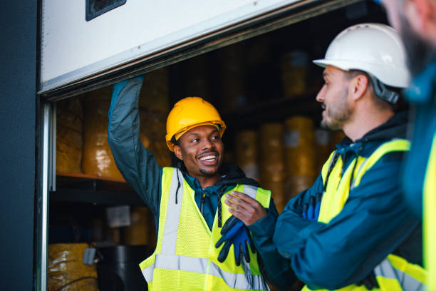 istock Two industrial warehouse workers in safety helmets and reflective vests engage joyfully near the storage area, exemplifying teamwork and workplace safety. 2148771432