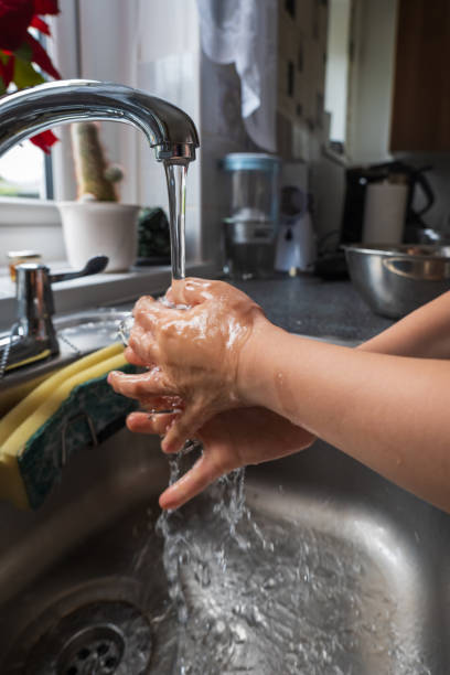 istock Child washes hands in sink, scrubbing fingers and nails 2148772092