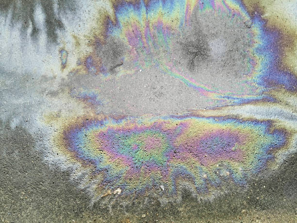 istock Close up of rainbow colored paint stain on asphalt road surface 2148772523