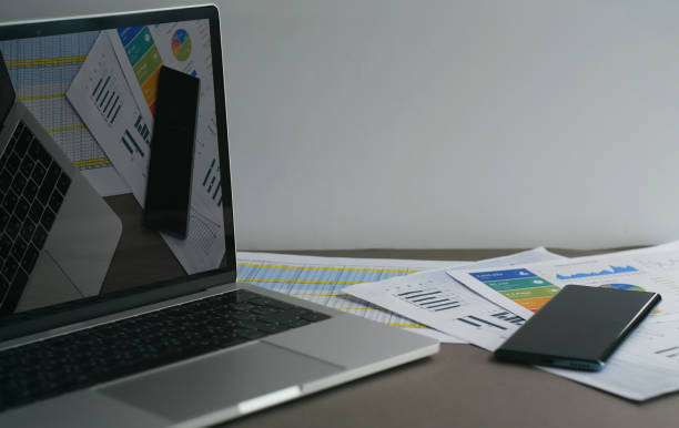 istock Computer with financial graphs on monitor standing on table in office 2148772720