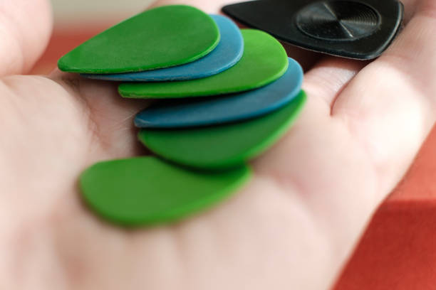 Close-up view of guitar picks on hand palm. Colorful ones and a black one. Hobbies and artistic lifestyle. Analog hobbies.