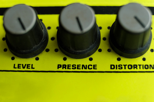 Close-up of part of a distortion guitar pedal. Only knobs in the image. Authentic music sound.