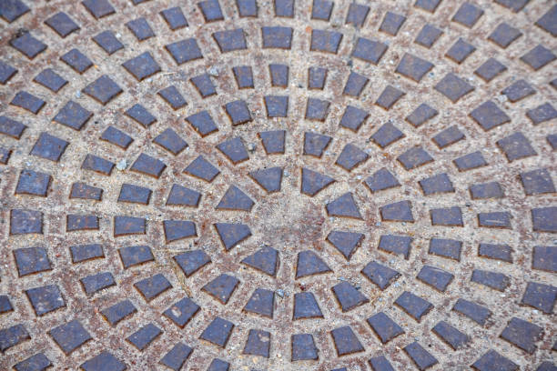 cast iron manhole cover with cast squares on it.