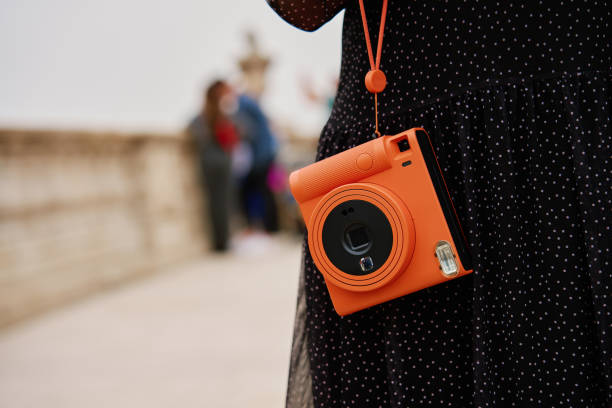 istock Female traveler holding vintage instant camera 2148773483