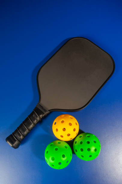 istock Paddle and pickleball ball in blue background. Pickleball is a new sport that is developing and starting to be popular with the public. 2148778772