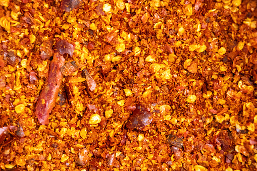 Crushed red pepper background. Dried red chili flakes and seeds texture.