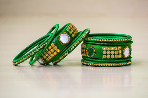 Handmade bangles decorated with silk thread, mirror cut, and beads.
